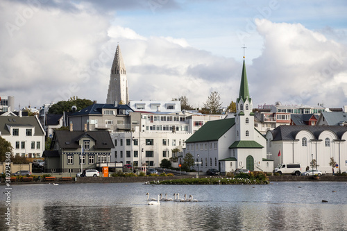 LAKE TJÖRNIN, REYKJAVIK, ICELAND - SEPTEMBER 18, 2018: View of lake Tjörnin and cityscape with buildings, houses and Hallgrímskirkja in the background.
