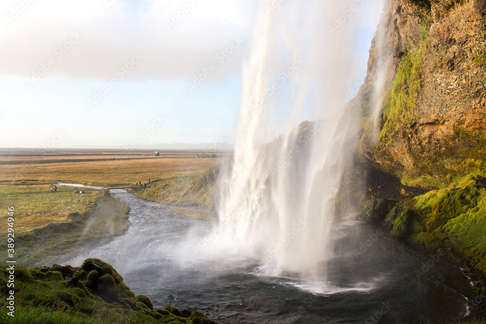 SELJALANDSFOSS, ICELAND - SEPTEMBER 19, 2018: Seljalandsfoss waterfall on Seljalands River in South Iceland, its one of the most famous and visited waterfalls in Iceland. Photographed from behind.