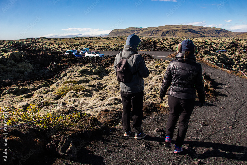 ELDHRAUN LAVA FIELD, ICELAND - SEPTEMBER 19, 2018: Couple of tourists visit moss covered lava fields in South Iceland during a sunny autumn day.