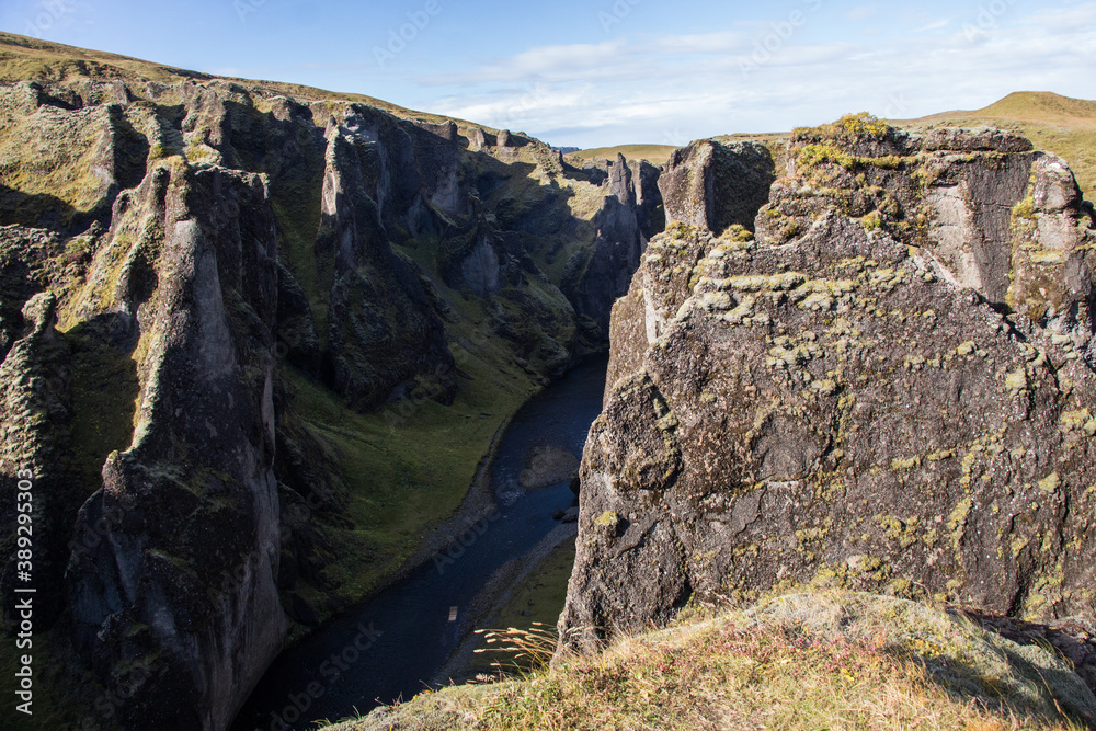FJADRARGLJUFUR, ICELAND - SEPTEMBER 20, 2018: Rock formations at Fjadrargljufur canyon and Fjadra river in south east Iceland during a sunny autumn day. Hiking trail along the canyon.