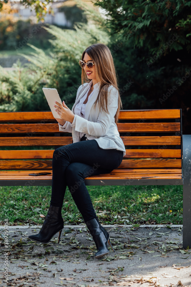 Beautiful businesswoman working on a tablet outdoor. Beautiful businesswoman working on a tablet outdoor.