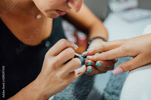 Young woman getting a beautiful manicure in the salon. The process of making nails.