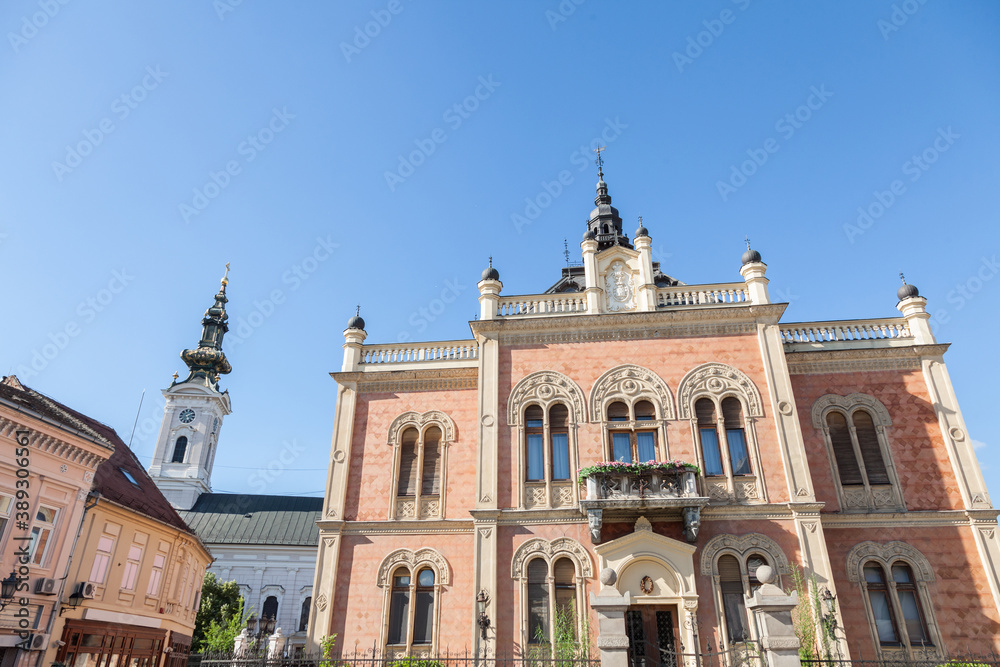 Facade of Vladicanski Dvor, the Bishop Episcopal palace of Novi Sad, Serbia, with its typical Austro hungarian architecture, with the Saborna crkva church, an Orthodox cathedral, in the background