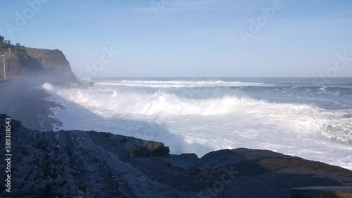 Giant waves crashing against a wall and splashing large amounts of water in form of foam