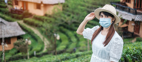 Happy tourist woman wearing surgical face mask  enjoy beautiful Tea garden  protection Coronavirus disease  Covid-19  infection. New Normal  travel  vacation and holiday concept