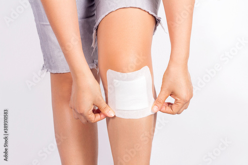 Photos Female putting adhesive plaster wound sealed on khee on white background