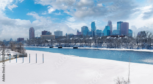 Downtown Minneapolis Winter View From Boom Island Park and Mississippi River with cloudy blue sky background photo