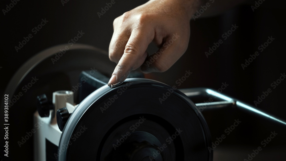 Man rubbing pasta with his finger on a rotating grinder Man rubbing pasta with his finger on a rotating grinder