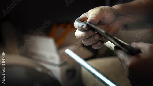 The man checks the sharpness of the ax with his finger