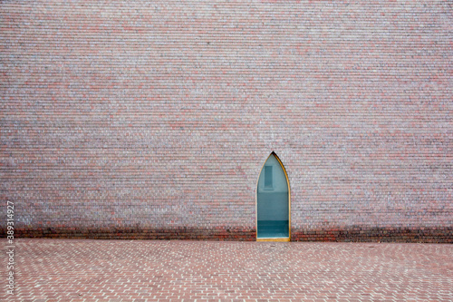 Artistic red bricks wall with unique turquoise window, outside the Unterlinden Museum in Colmar,  designed by architects Herzog & de Meuron. photo