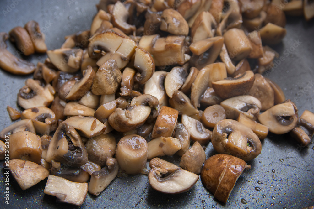 Close up view of sauteed slices of Common Mushrooms (Agaricus bisporus) cooking in the pan Close up view of sauteed slices of Common Mushrooms (Agaricus bisporus) cooking in the pan