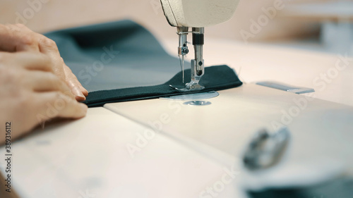 Woman seamstress works at a sewing machine