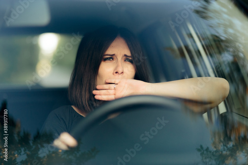 Sleepy Female Driver Yawning Behind the Wheel photo