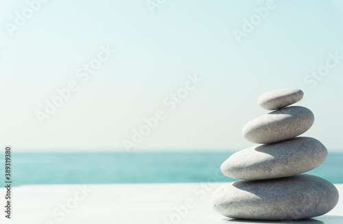 Zen relax background. A pyramid of stones on the beach in clear sunny weather. Background for meditation  yoga and massage