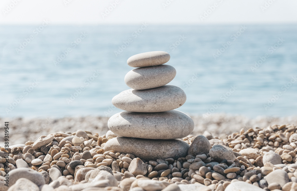 Zen relax background. A pyramid of stones on the beach in clear sunny weather. Background for meditation, yoga and massage Zen relax background. A pyramid of stones on the beach in clear sunny weather. Background for meditation, yoga and massage