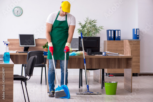 Young male contractor cleaning the office