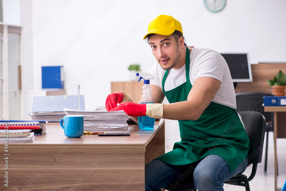Young male contractor cleaning the office Young male contractor cleaning the office