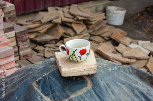 A bright mug with coffee stot on the ruins. Contrast.