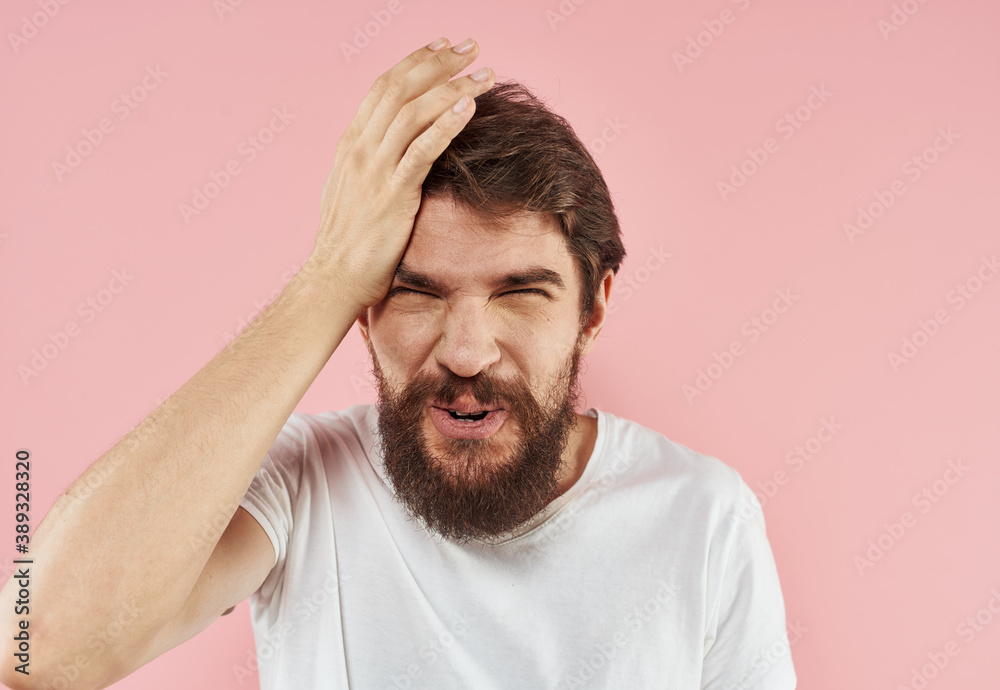 Surprised man holding hand near face emotions pink background cropped view Surprised man holding hand near face emotions pink background cropped view