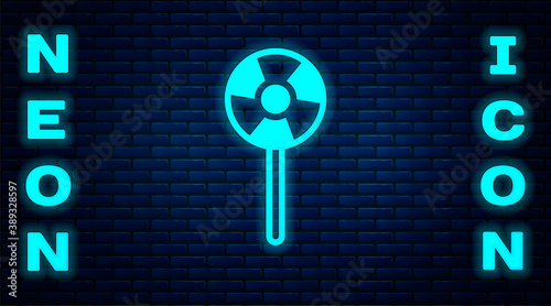 Glowing neon Lollipop icon isolated on brick wall background. Candy sign. Food, delicious symbol. Vector.