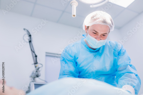 Surgeon in operating room with surgery equipment.