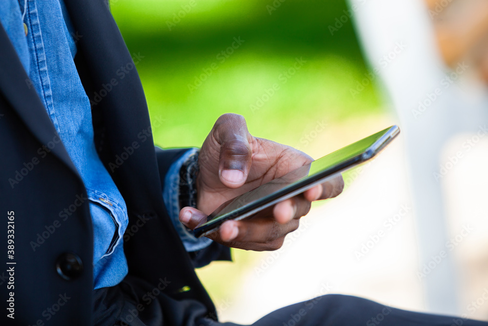 Close up of a black man hand holding a cellphone texting messages concerning business matters