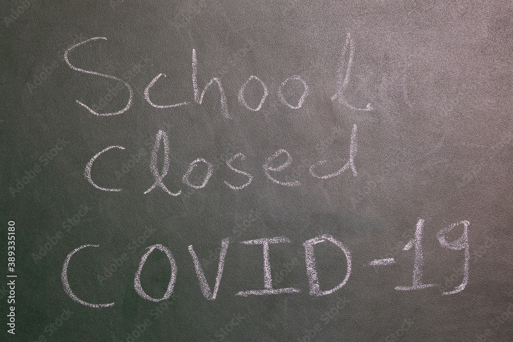 Fototapeta premium School Closed due to coronavirus notice on the green board written with chalk at the school.
