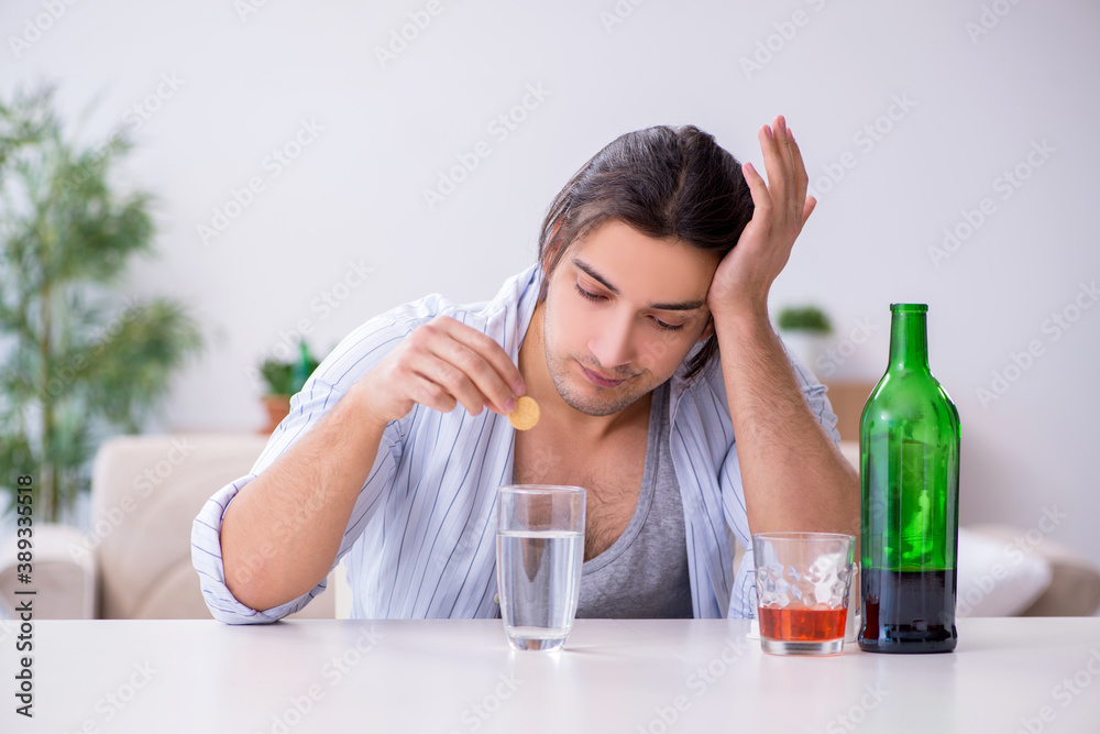 Young male alcoholic drinking whiskey at home Young male alcoholic drinking whiskey at home