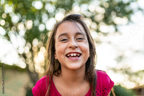 Happy cute child girl on the blur green background. Kid on the farm. Latin people.