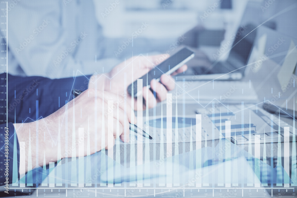 Double exposure of man's hands holding and using a digital device and forex graph drawing. Financial market concept. Double exposure of man's hands holding and using a digital device and forex graph drawing. Financial market concept.