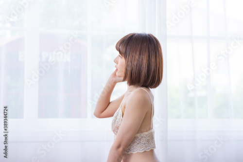 Portrait of young pretty sexy Asian woman wearing white bikini in her room. Free Download Portrait of young pretty sexy Asian woman wearing white bikini in her room. - GFXLoad