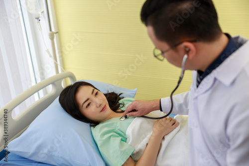 Asian doctor is using a stethoscope listen to the heartbeat of the patien