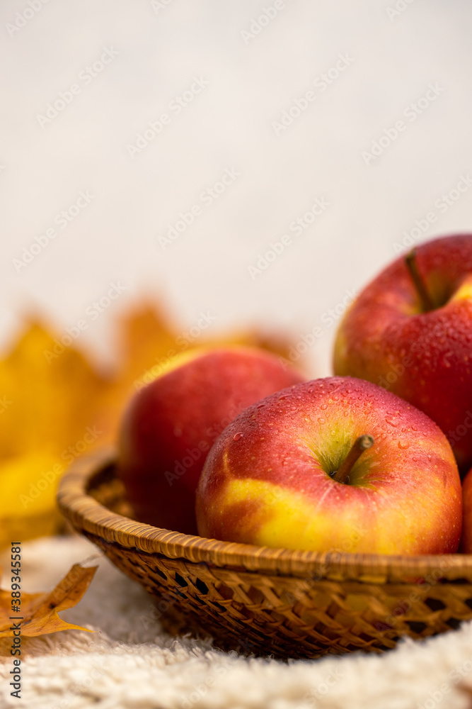 Colourful autumn apples and leaves in a basket Colourful autumn apples and leaves in a basket