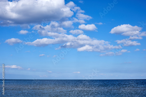 calm sea waters against a blue sky with clouds