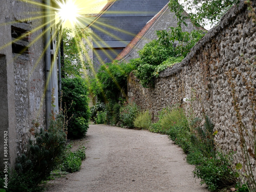 Weg in französischem Dorf mit Sonnenstrahlen