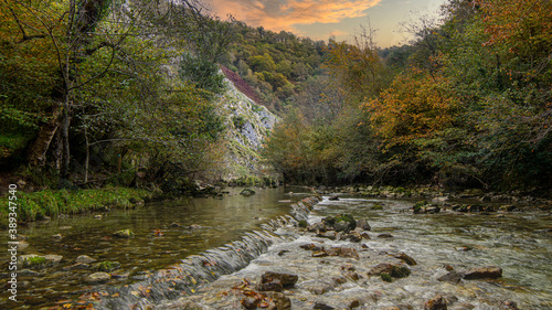 Rio de montaña con aguas puras y cristalinas a su paso por un bosque en otoño. photo