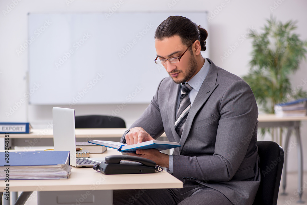 Young male employee working in the office Young male employee working in the office
