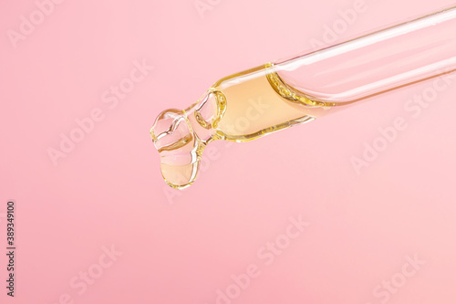 Pipette with essential oil on a pastel pink background. The concept of beauty, skin care, aromatherapy, spa, cosmetology. Close-up, detailed macro photo... photo