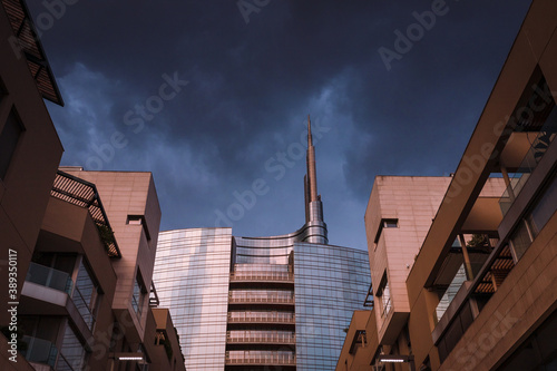 Unicredit tower in Gae Aulenti square at sunset before a storm. Sky with clouds photo