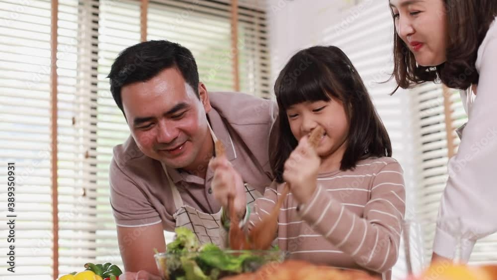 Happy family enjoy cooking salad spending time together for breakfast meal in modern kitchen home in the morning. Happy family enjoy cooking salad spending time together for breakfast meal in modern kitchen home in the morning.