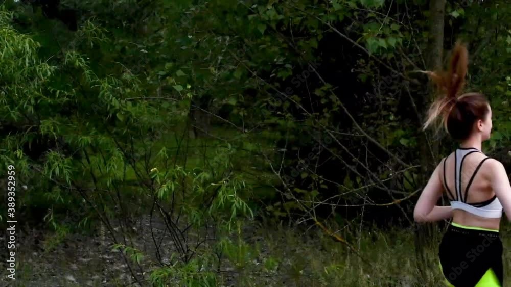 Slender girl goes in for sports and runs through the woods in nature in sports clothes. The concept of a healthy lifestyle. Slender girl goes in for sports and runs through the woods in nature in sports clothes. The concept of a healthy lifestyle.