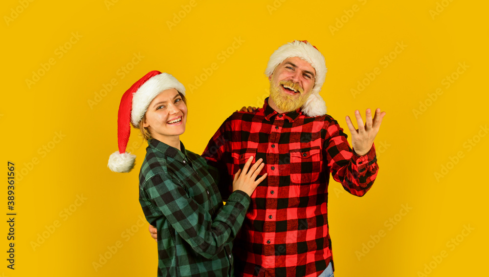Family wear santa hats. Entertainment ideas for adults. Santa team. Loving couple yellow background. Christmas magical time. We love christmas. Couple in love enjoy christmas holiday celebration Family wear santa hats. Entertainment ideas for adults. Santa team. Loving couple yellow background. Christmas magical time. We love christmas. Couple in love enjoy christmas holiday celebration