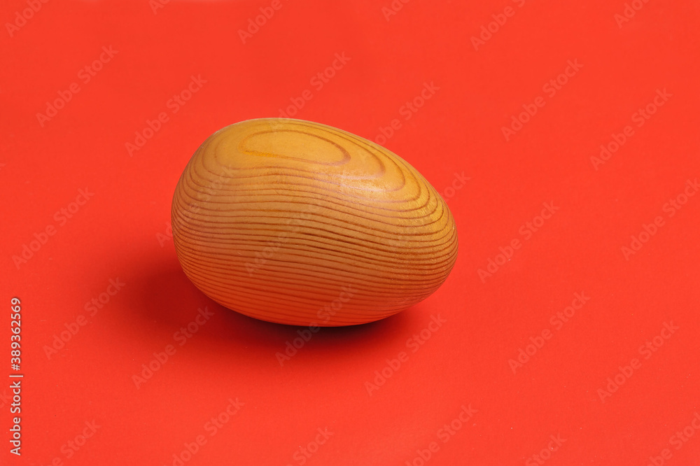 Wooden egg on a red background close-up Wooden egg on a red background close-up