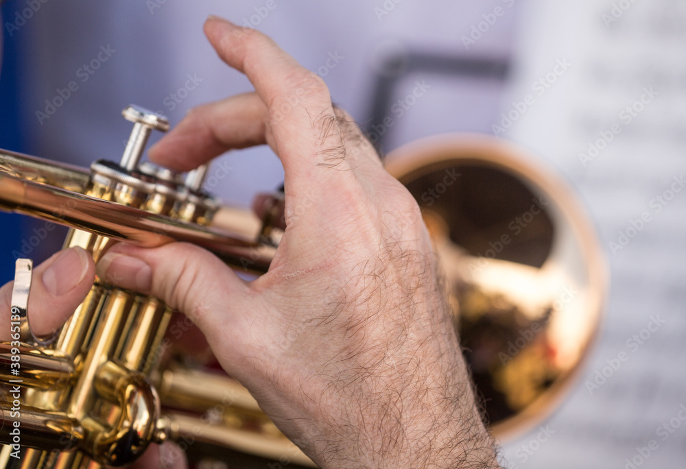 Obraz premium Close up of a musicians hand playing the trumpet