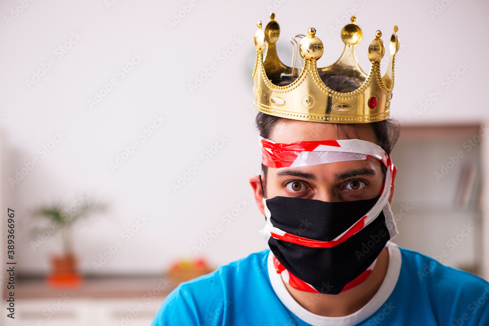 Young man with crown on head at home Young man with crown on head at home