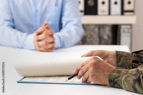 Konstfotografi Cropped shot of a man and military man completing paperwork together at a desk