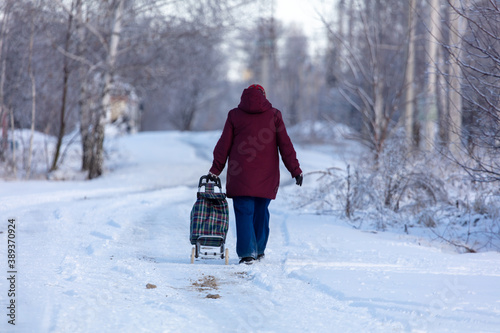 A woman with a bag walks along a snowy road