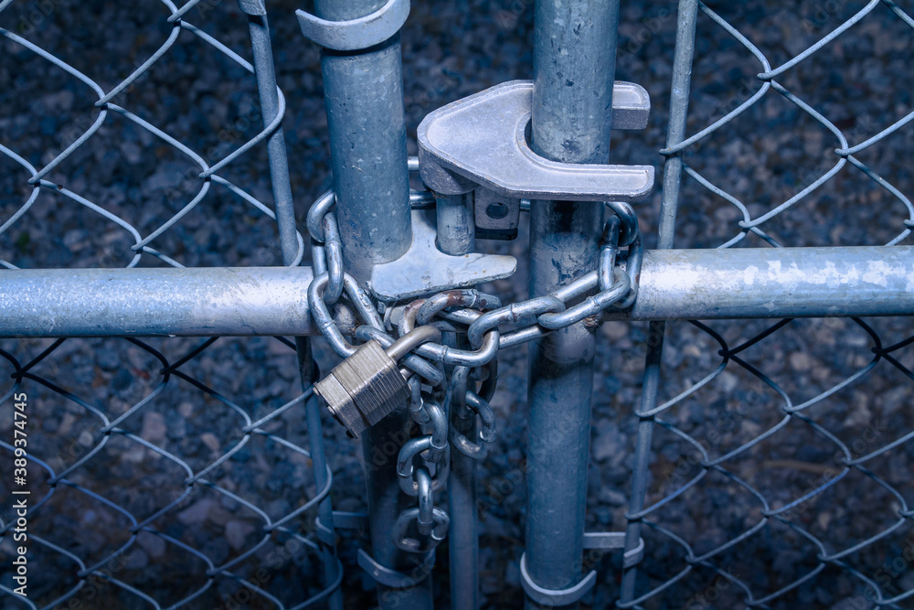 Padlock and chain on a chain link fence gate