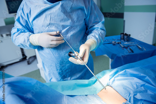 Surgeon performs endoscopic microdiscectomy of herniated intervertebral disc.