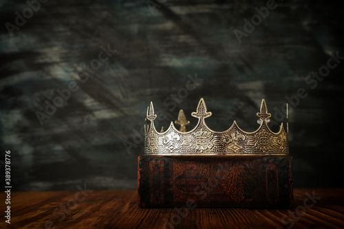 low key image of beautiful queen/king crown on old book. vintage filtered. fantasy medieval period